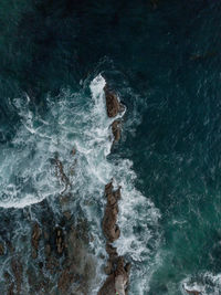 Aerial view of sea waves splashing on rocks