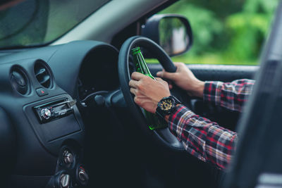 Midsection of man using smart phone in car