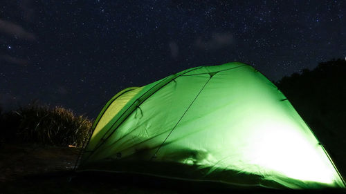 Low angle view of illuminated tent against sky at night