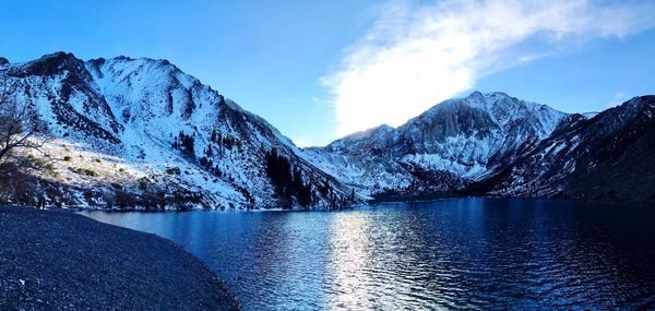 Scenic view of lake and snowcapped mountains against sky