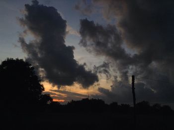 Low angle view of silhouette trees against sky