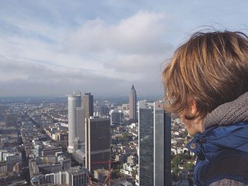 Rear view of woman with cityscape in background