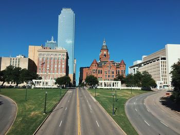 Empty road along buildings