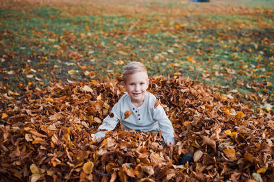 A happy boy stands in the autumn forest. person