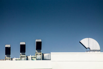 Low angle view of modern building against clear blue sky