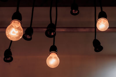 Low angle view of light bulb hanging on ceiling