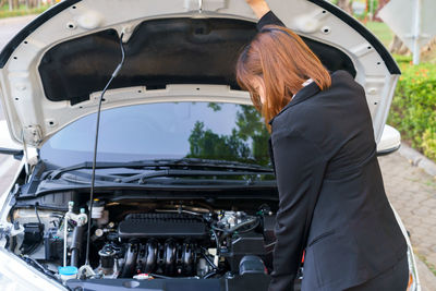 Rear view of woman standing in car