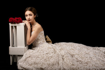 Portrait of a beautiful young woman over black background