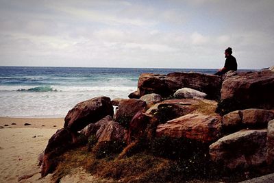 Scenic view of beach against cloudy sky