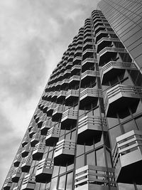 Low angle view of skyscraper against cloudy sky