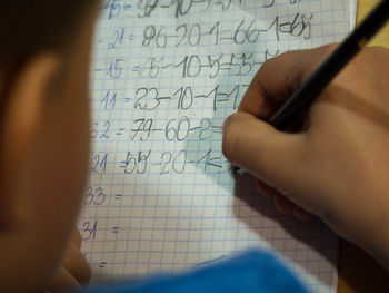 Cropped image of boy learning mathematics on table