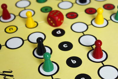 Close-up of game pieces and dice on ludo