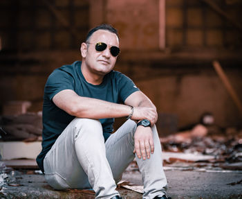 Portrait of young man wearing sunglasses sitting outdoors