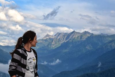 Woman standing on mountain against sky