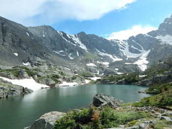 Scenic view of river and mountains against sky