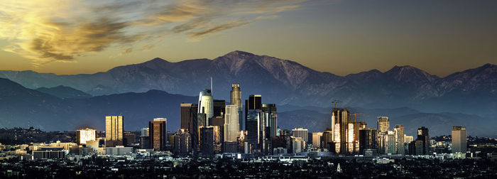 Panoramic view of buildings against cloudy sky during sunset