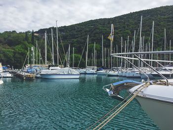 Boats moored at harbor against sky