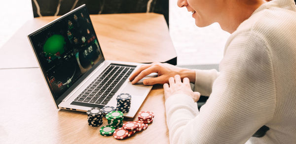 Midsection of woman using laptop at table