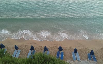 Deck chairs on beach by sea