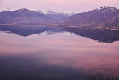 Scenic view of lake and mountains against sky during sunset