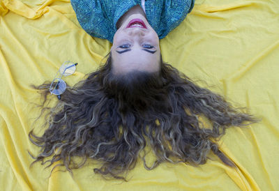 Smiling young woman lying on picnic blanket