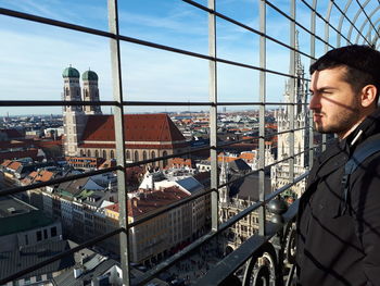 Side view of man looking city from bridge 