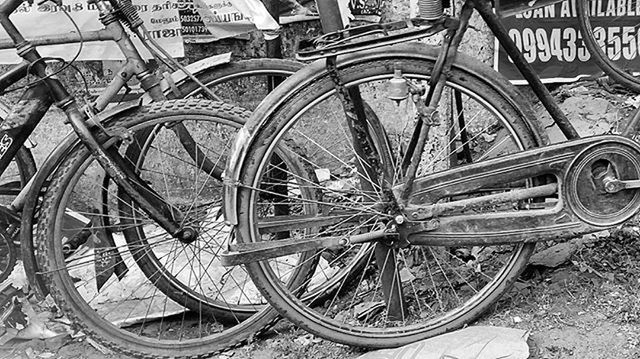 wheel, bicycle, transportation, land vehicle, metal, old, built structure, stationary, tire, abandoned, day, no people, mode of transport, architecture, outdoors, wall - building feature, pattern, high angle view, parking, rusty