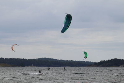 Scenic view of sea against sky people kite