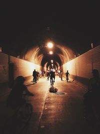 People walking in illuminated tunnel