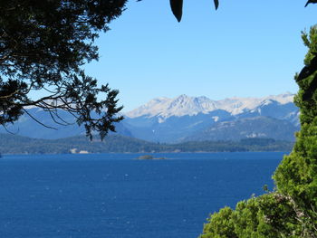 Scenic view of sea and mountains against blue sky