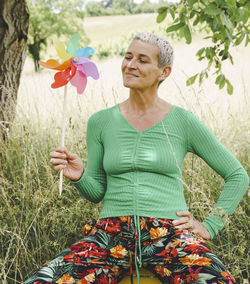 Portrait of young woman standing against plants