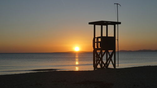 Scenic view of lifeguard tower at beach during sunset