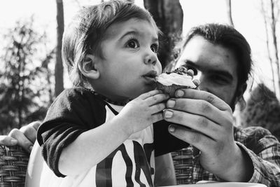 Close-up of father feeding cake to son