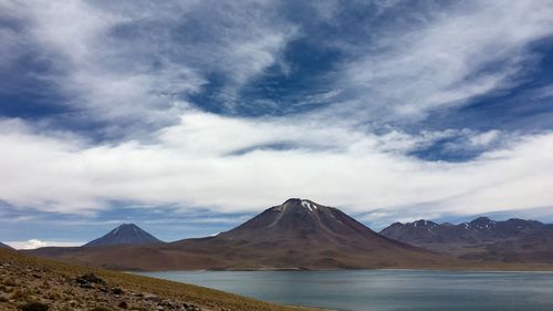 Scenic view of mountain range against cloudy sky