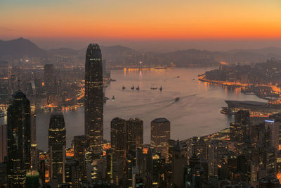 Illuminated cityscape against sky during sunset