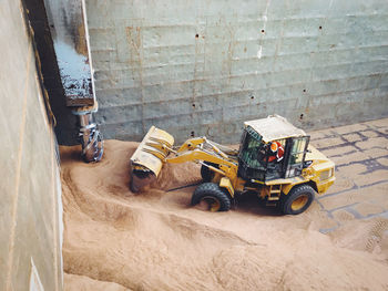 High angle view of bulldozer on sand at construction site