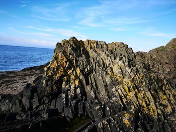 Rock formations by sea against sky