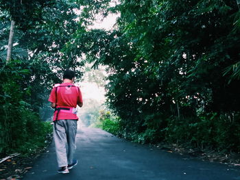 Rear view of man walking on footpath