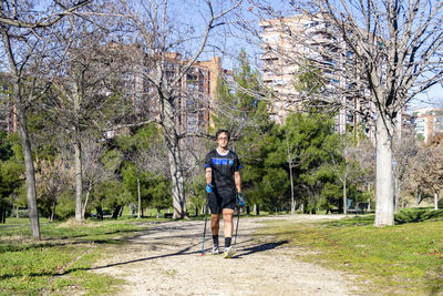 Nordic walking. young person practicing the sport nordic walking with poles in an outdoor park