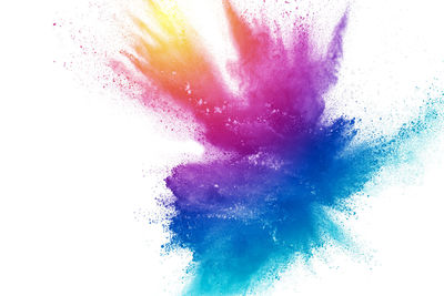 Defocused image of multi colored powder paints against white background