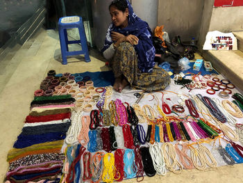 Full length of man sitting at market stall