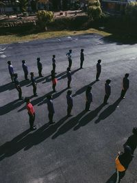 High angle view of people standing in row on road