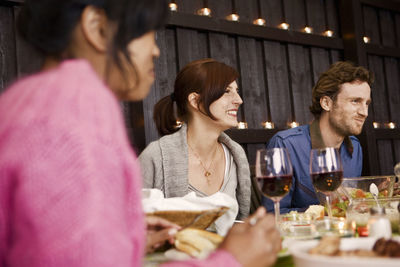 Smiling young people at dinner party