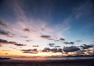 Scenic view of sea against dramatic sky during sunset