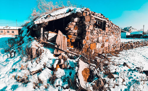 Old abandoned building against sky during winter