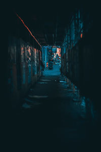 Illuminated street amidst buildings at night