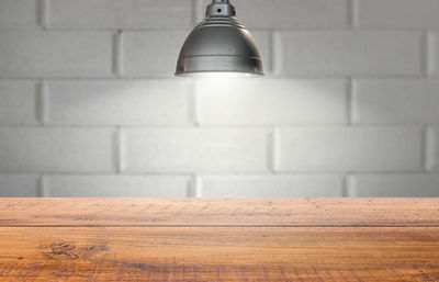 Close-up of electric lamp on wall at home