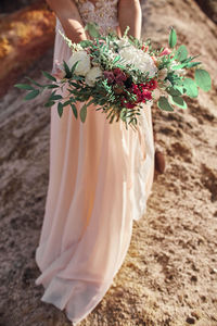 Midsection of woman holding bouquet