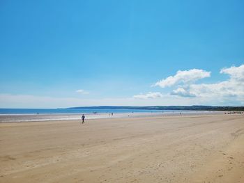 Scenic view of beach against blue sky