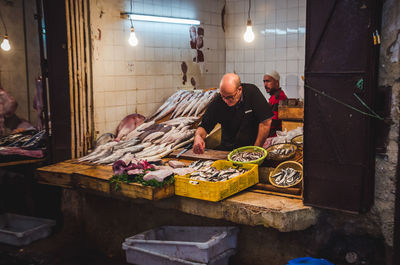 People working at illuminated shop